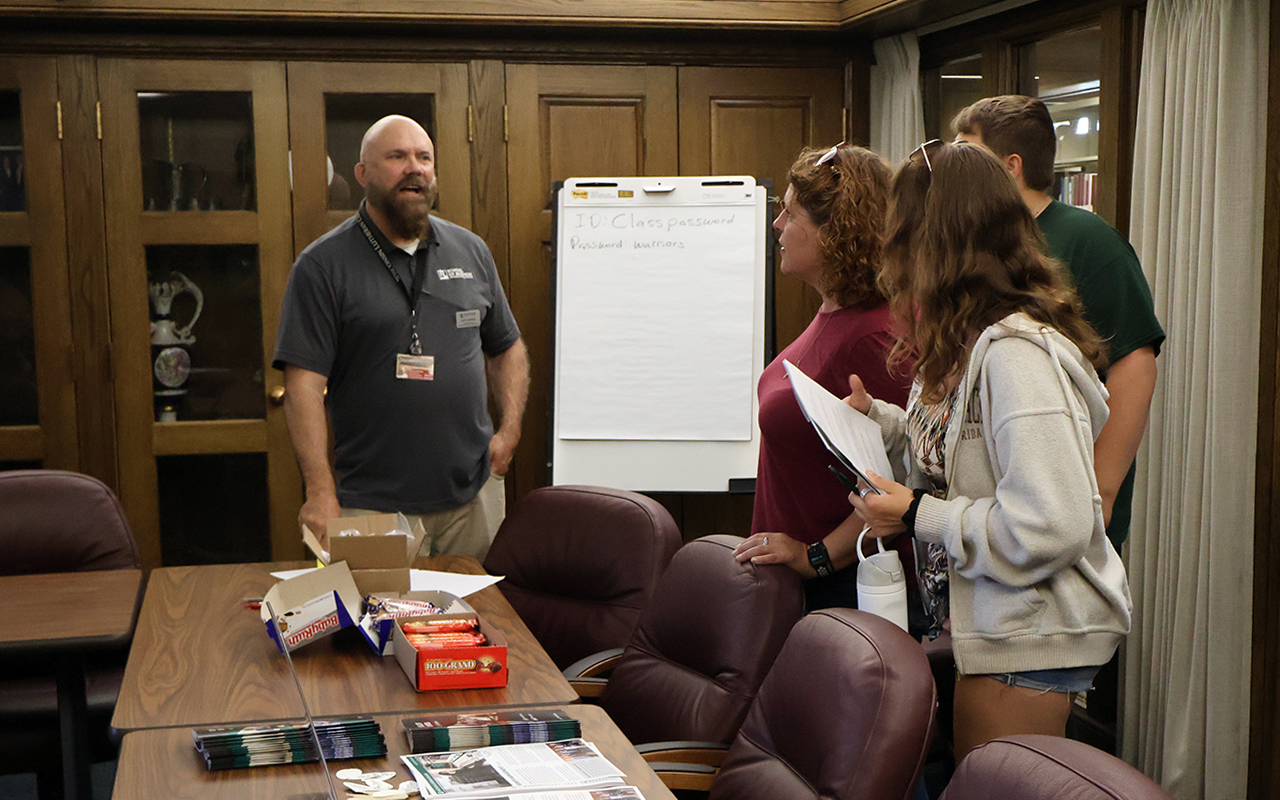 professor talking to guests by table